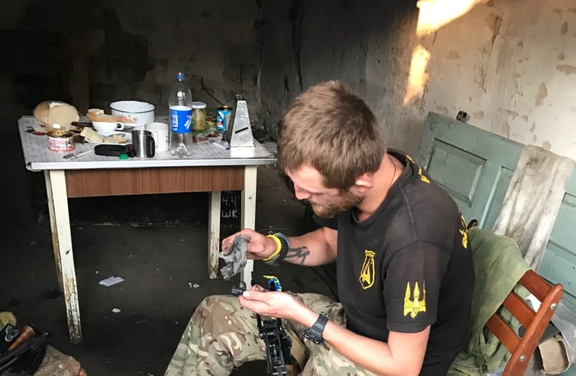 A Ukraine Donbass volunteer cleans his rifle, Summer 2017. (photo credit: SETH J. FRANTZMAN)