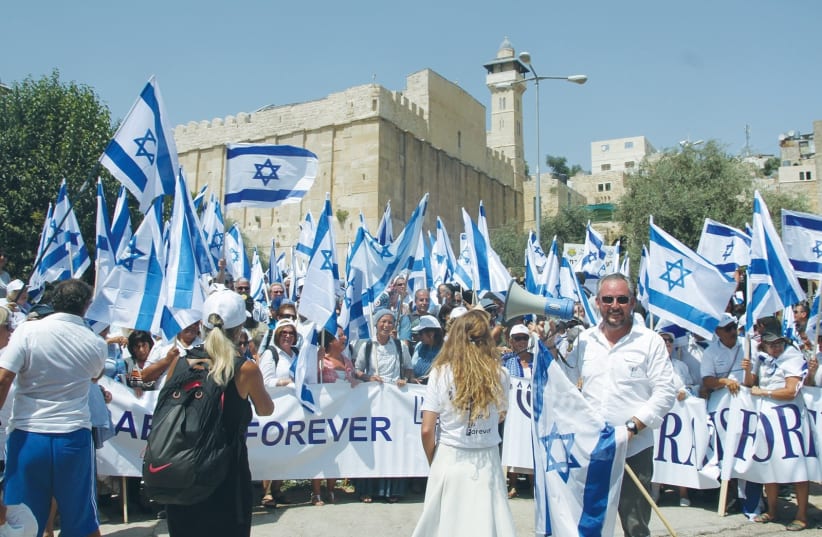PARTICIPANTS IN the annual Hebron march show the flag, with the Tomb of the Patriarchs in the background (photo credit: TOVAH LAZAROFF)