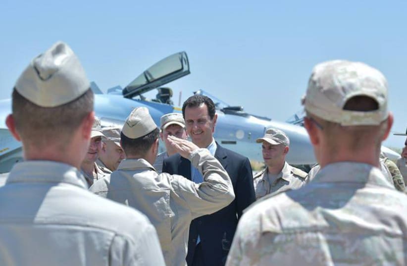 Syria's President Bashar al-Assad visits a Russian air base at Hmeymim, in western Syria (photo credit: SANA/REUTERS)