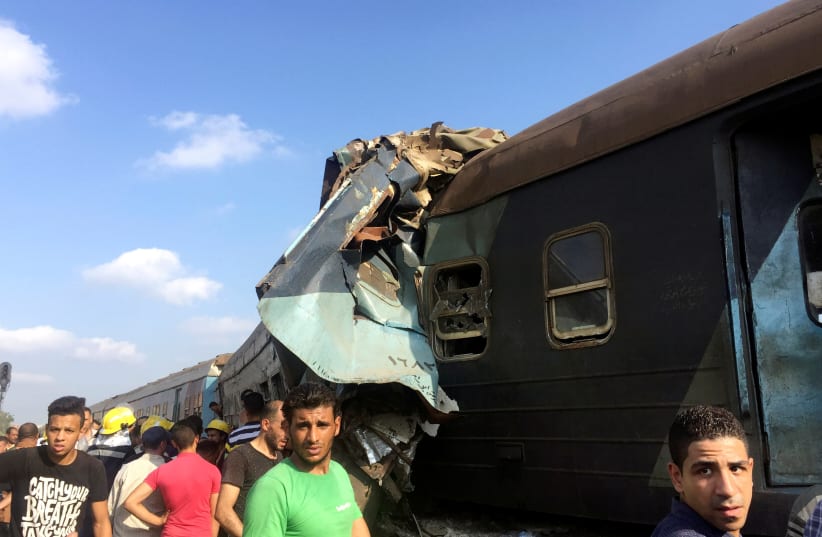 Egyptians look at the crash of two trains that collided near the Khorshid station in Egypt's coastal city of Alexandria, Egypt August 11, 2017 (photo credit: REUTERS/OSAMA NAGEB)
