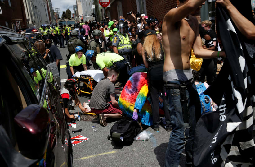 Rescue workers assist people who were injured when a car drove through a group of counter protestors at the "Unite the Right" rally Charlottesville, Virginia, US, August 12, 2017. (photo credit: JOSHUA ROBERTS / REUTERS)