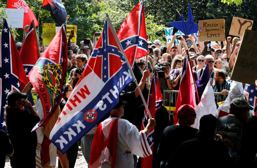 Members of the Ku Klux Klan face counter-protesters as they rally in support of Confederate monuments in Charlottesville, Virginia, U.S. July 8, 2017 (photo credit: REUTERS / JONATHAN ERNST)