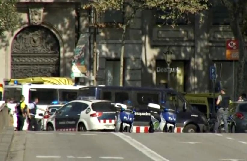 A still image from video shows a police cordon on a street in Barcelona, Spain following a van ramming (photo credit: REUTERS TV)