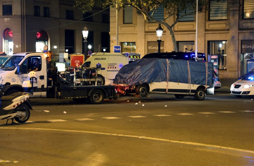 The suspected van is towed away from the area where it crashed into pedestrians at Las Ramblas in Barcelona, Spain, August 18, 2017. (photo credit: REUTERS/SERGIO PEREZ)