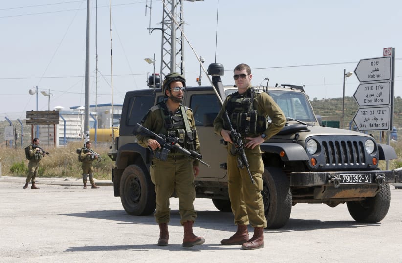 Israeli soldiers stand guard near the scene of an attack at Tapuach junction near the West Bank city of Nablus April 30, 2013 (photo credit: REUTERS)