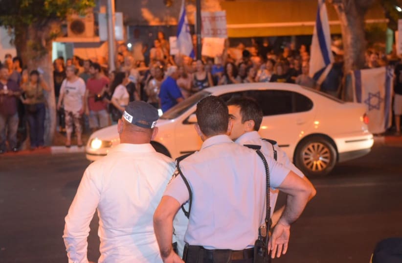 Israeli police watch protestors in Petah Tikva, August 19, 2017. (photo credit: AVSHALOM SASSONI/MAARIV)