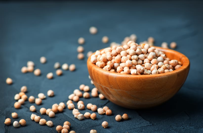 raw chickpea in bowl and on a table (photo credit: INGIMAGE)