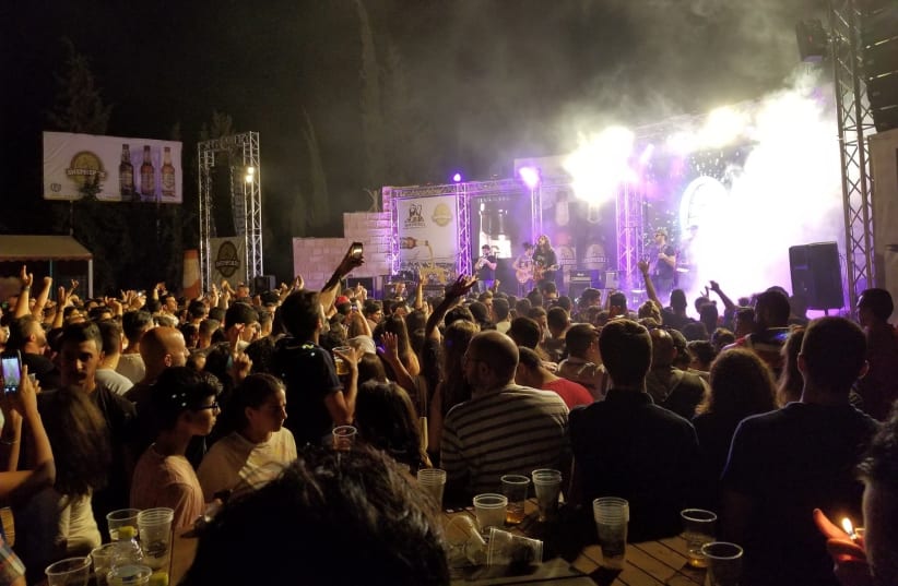 Palestinians and foreigners watch popular Palestinian band Apo and the Apostles perform at the Shepherds beer festival in Beit Sahur on August 19, 2017. (photo credit: ADAM RASGON)