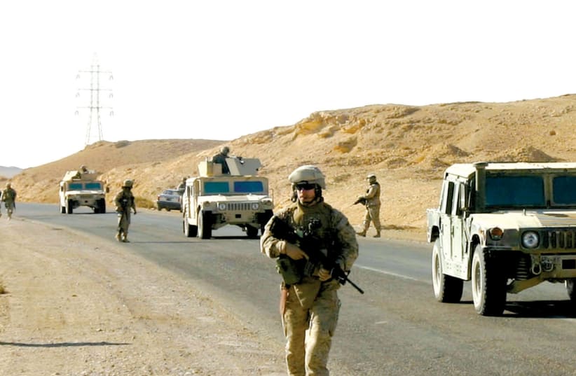 US MARINES scour a road looking for improvised explosive devices near Hit, 170 km. west of Baghdad, in December 2005. (photo credit: REUTERS)
