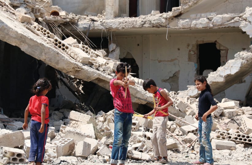 CHILDREN AT play in a rebel-held part of the Syrian city of Deraa on Sunday. (photo credit: ALAA AL-FAKIR / REUTERS)