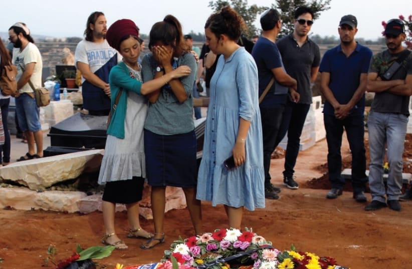 FAMILY AND FRIENDS mourn at the graves of Yosef, Chaya and Elad Salomon, who were buried at the Modi’in Cemetery, on July 23. ( (photo credit: REUTERS)