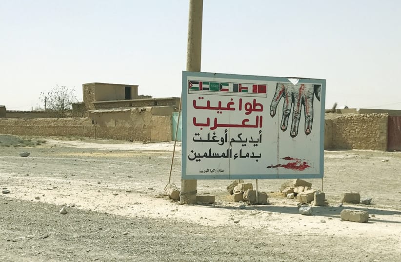 THE SIGN, which says ‘Arab tyrants are responsible for the bloodshed of Muslims,’ was erected by ISIS on the road to Tel Afar in Iraq. (photo credit: COURTESY MAJD HELOBI)