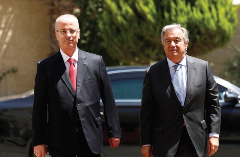 PA Prime Minister Rami Hamdallah (left) walks with UN Secretary-General Antonio Guterres yesterday during a reception ceremony in Ramallah. (photo credit: MOHAMAD TOROKMAN/REUTERS)