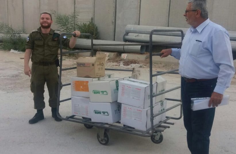 IDF LT. LIOR SHWEITZER (left) prepares the delivery to Gaza of pesticide at a border crossing last week (photo credit: COGAT SPOKESPERSON'S UNIT)