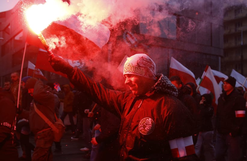 Protesters light flares and carry Polish flags during a rally, organised by far-right, nationalist groups, to mark the anniversary of Polish independence in Warsaw, Poland, November 11, 2016. (photo credit: REUTERS)
