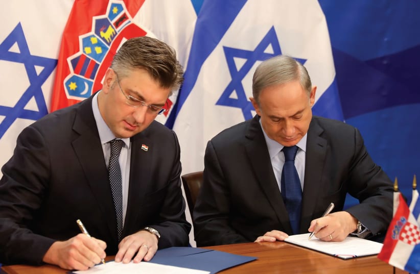 PRIME MINISTER Benjamin Netanyahu and his Croatian counterpart, Andrej Plenkovic, sign a bilateral agreement in Jerusalem in January. (photo credit: REUTERS)