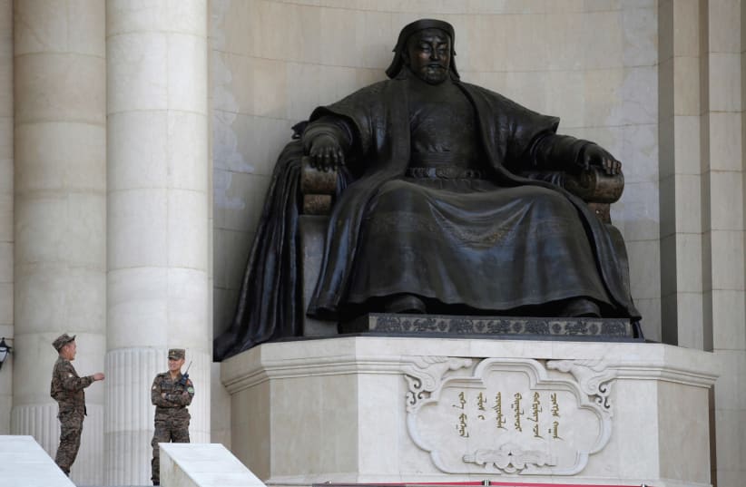 Security personnel chat next to the statue of Genghis Khan at the parliament building in Ulaanbaatar, Mongolia. (photo credit: REUTERS)