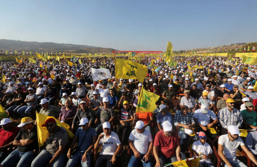 Supporters of Lebanon's Hezbollah leader Sayyed Hassan Nasrallah display Hezbollah flags during a rally marking the 11th anniversary of the end of Hezbollah's 2006 war with Israel, in the southern village of Khiam, Lebanon August 13, 2017. (photo credit: AZIZ TAHER/REUTERS)