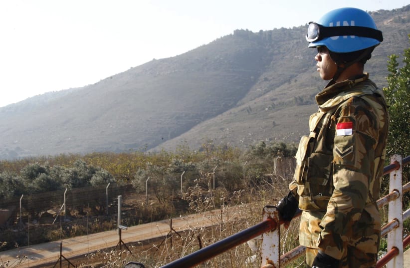 A PEACEKEEPER of the United Nations Interim Force in Lebanon (UNIFIL) stands at a lookout point in the village of Adaisseh near the Lebanese-Israeli border. (photo credit: REUTERS/KARAMALLAH DAHER)