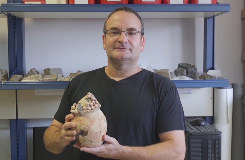 Prof. Danny Rosenberg, of the Zinman Institute of Archaeology at the University of Haifa, holds the ancient vessel. (photo credit: UNIVERSITY OF HAIFA)