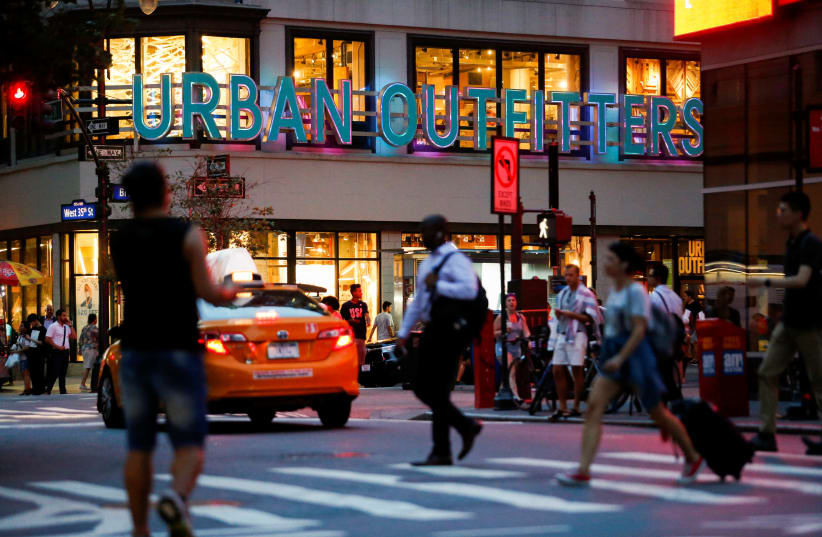 People crosses the street next to the Urban Outfitters store in Manhattan, New York (photo credit: REUTERS/EDUARDO MUNOZ)
