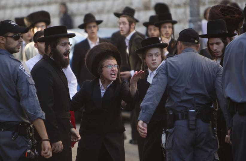 Ultra-Orthodox Jews shout at a policeman during a protest against the opening of a road on the Sabbath, near a religious neighbourhood in Jerusalem June 23, 2012. (photo credit: REUTERS)