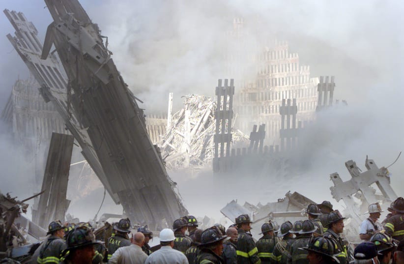 A group of firefighters stand in the street near the destroyed World Trade Center in New York on September 11, 2001. (photo credit: REUTERS)