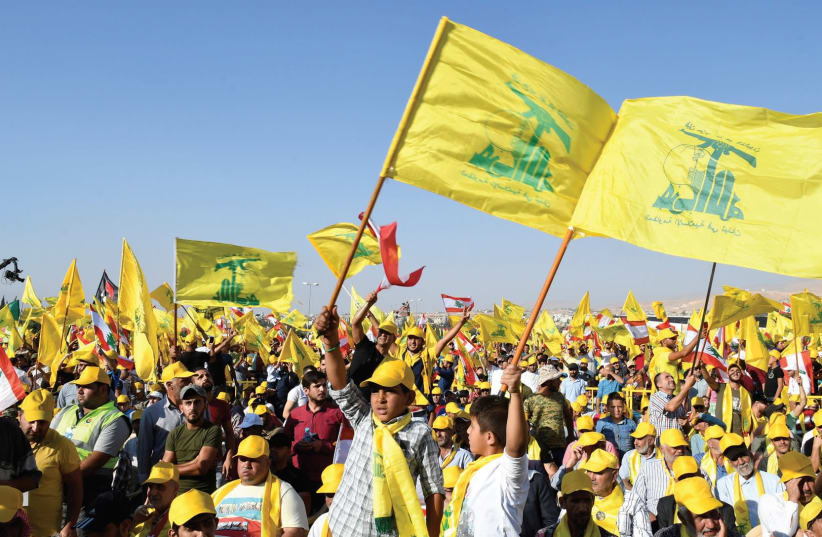SUPPORTERS OF Hezbollah leader Sayyed Hassan Nasrallah display Hezbollah and Lebanese flags in Lebanon’s Bekaa valley.  (photo credit: REUTERS)