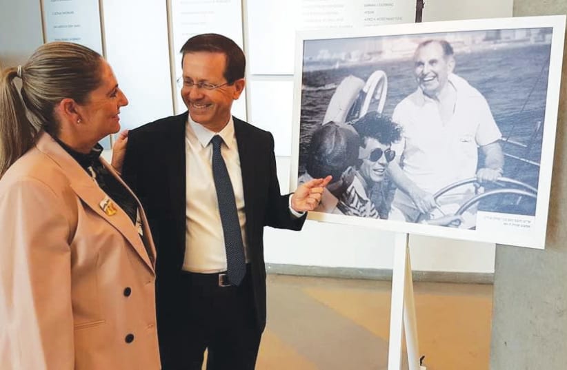 Michael and Isaac Herzog look at a photo of his father, Israel’s sixth president Chaim Herzog, indulging in his favorite sport – sailing. (photo credit: FACEBOOK)