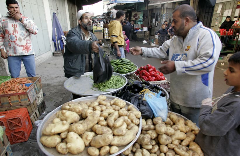 A Palestinian vendor sells vegetables at a market in Gaza City (photo credit: ISMAIL ZAYDAH / REUTERS)