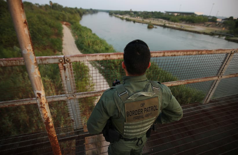 A US border patrol agent looks over the Rio Grande river at the border between United States and Mexico, in Roma, Texas, US, May 11, 2017 (photo credit: REUTERS)