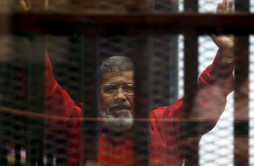 Ex-President Mohammad Morsi seen through prison bars in 2016  (photo credit: REUTERS/AMR ABDALLAH DALSH)