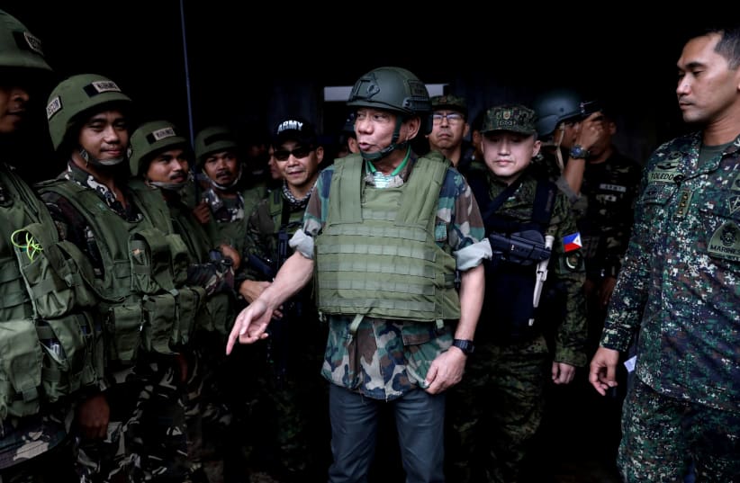  Philippine President Rodrigo Duterte wears a bulletproof vest and a helmet as he gives a pep talk to troops fighting the extremist Maute group in Marawi, Philippines August 24, 2017. (photo credit: REUTERS)