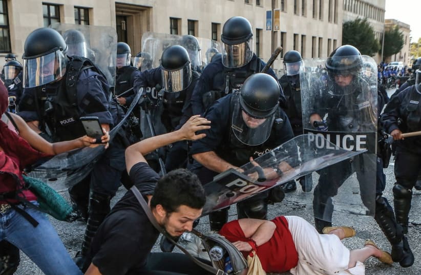 PROTESTERS FALL AS they are pushed back by St. Louis riot police during a protest on Friday following a not-guilty verdict in the murder trial of former police officer Jason Stockley (photo credit: REUTERS)