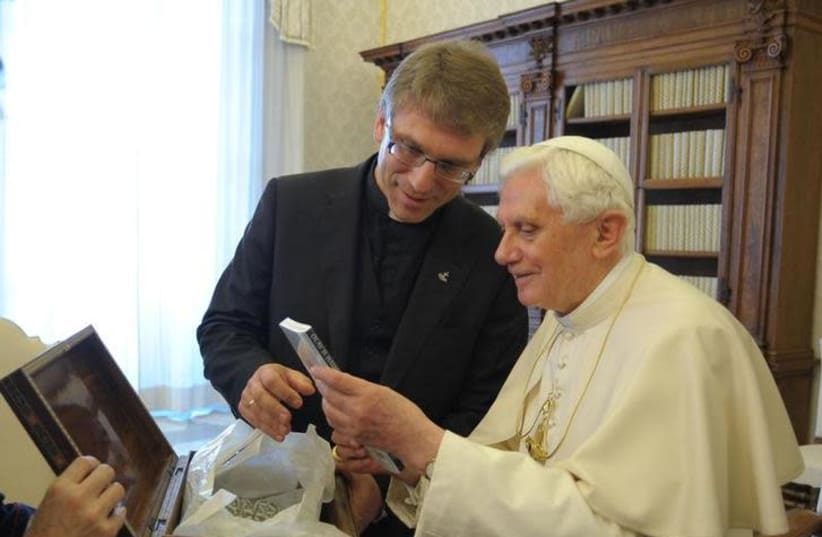 Pope Benedict XVI receives a book by Rev. Dr Olav Fykse Tveit, general-secretary of the World Council of Churches (WCC) (photo credit: OSSERVATORE ROMANO / REUTERS)