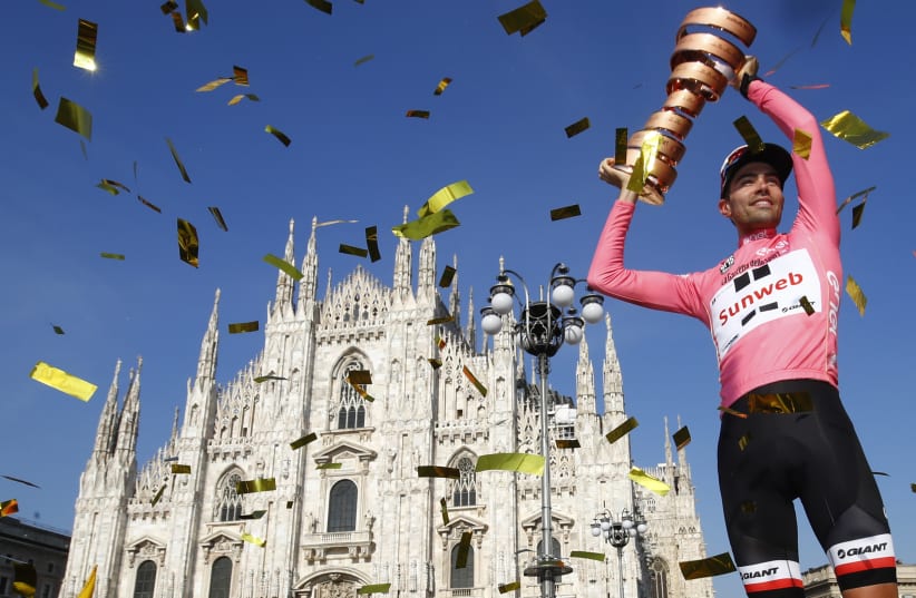 The winner of the 100th Giro d'Italia, Tour of Italy cycling race, Netherlands' Tom Dumoulin holds the trophy on the podium near Milan's cathedral after the last stage on May 28, 2017. (photo credit: AFP PHOTO)