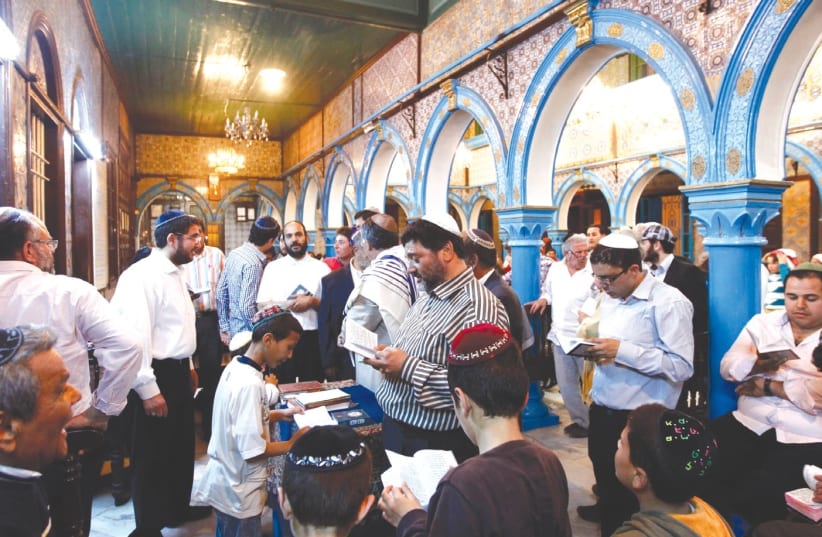 JEWISH MEN pray inside the blue-tiled El Ghriba synagogue on the Tunisian island of Djerba following a wedding ceremony (photo credit: REUTERS)