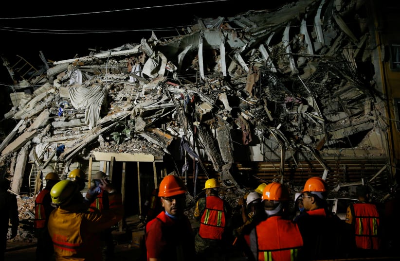 Rescuers work at a the site of a collapsed building after an earthquake in Mexico City (photo credit: REUTERS/HENRY ROMERO)