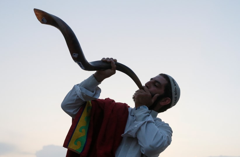 An ultra-Orthodox Jewish pilgrim blows a shofar, near the tomb of Rabbi Nachman of Breslov during the celebration of Rosh Hashanah holiday, the Jewish New Year, in Uman, Ukraine, September 21, 2017. (photo credit: REUTERS)