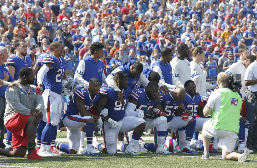Buffalo Bills players kneel in protest during the anthem before a game against the Denver Broncos (photo credit: TIMOTHY T. LUDWIG-USA TODAY SPORTS / REUTERS)