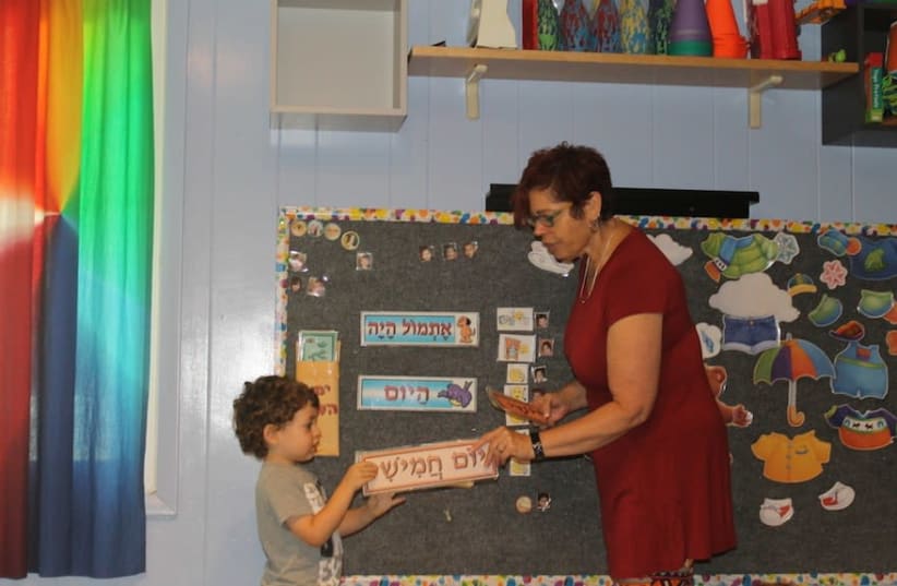 Tamar Pinto, who founded and runs the Gan Gurim preschool, teaching a student the Hebrew days of the week. (photo credit: BEN SALES)