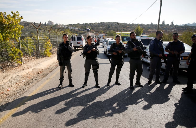 Border Police officers stand guard at the scene of the terror attack in Har Adar (photo credit: AMMAR AWAD / REUTERS)