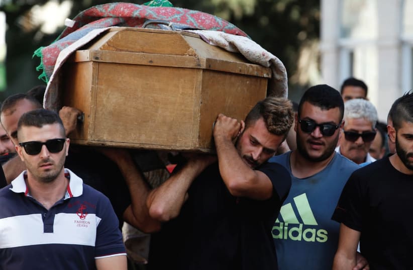 Relatives and friends carry the coffin of Youssef Othman, one of three guards killed in yesterday’s terrorist attack, during his funeral in Abu Ghosh. (photo credit: RONEN ZVULUN / REUTERS)