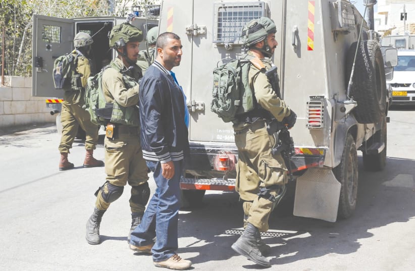 Soldiers arrest the brother of Har Adar terrorist Nimr Mahmoud Ahmad al-Jamal near Ramallah Tuesday. (photo credit: AMMAR AWAD / REUTERS)