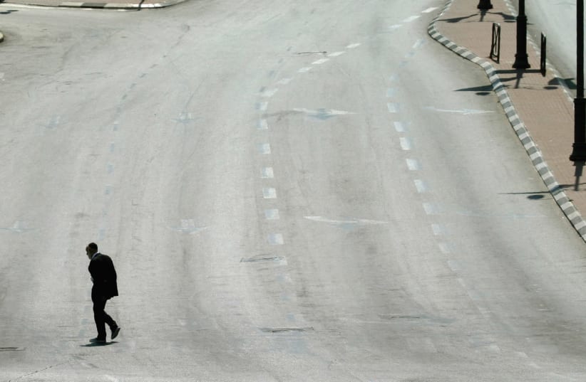 A MAN walks on an empty street in Jerusalem during Yom Kippur in this file photo from 2004. (photo credit: REINHARD KRAUSE/REUTERS)