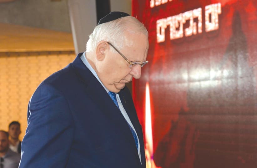 PRESIDENT REUVEN RIVLIN observes a moment of silence during a ceremony at Mount Herzl yesterday commemorating the outbreak of the 1973 Yom Kippur War. (photo credit: MARC NEYMAN/GPO)