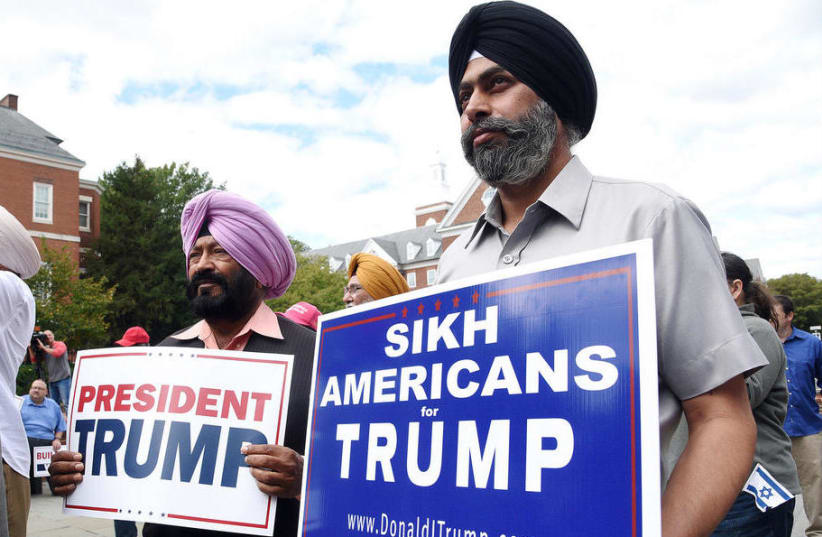 Sikh Trump supporters Manjit Singh Kario, left, and Dilvis Singh hold signs during a Making America Great Again, Already! Unity In Diversity for President Donald Trump rally at Lawyers' Mall in Annapolis, Maryland. (photo credit: PAUL W. GILLESPIE/CAPITAL GAZETTE)