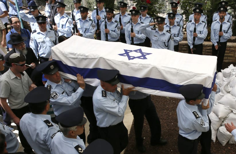 Israeli police officers carry the coffin, draped in the Israeli flag, of slain Chief Superintendent Baruch Mizrahi (photo credit: GALI TIBBON / AFP)