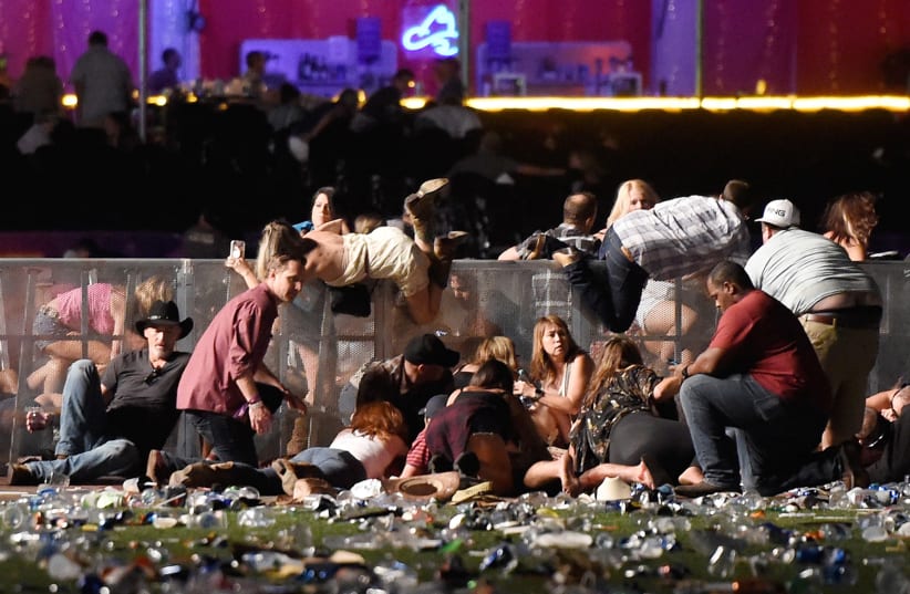 People scramble for shelter during a mass shooting at a music festival in Las Vegas (photo credit: DAVID BECKER/GETTY IMAGES/AFP)