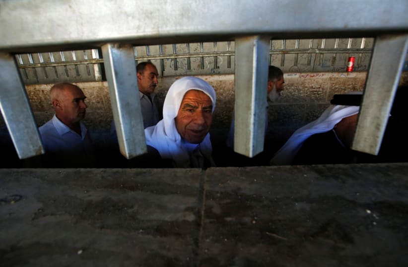 Palestinians cross an Israeli checkpoint in the West Bank city of Bethlehem (photo credit: MUSSA QAWASMA / REUTERS)